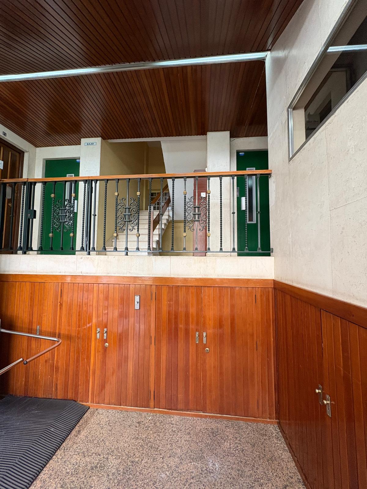 Zócalo de madera y buzones antiguos en el arranque de la escalera